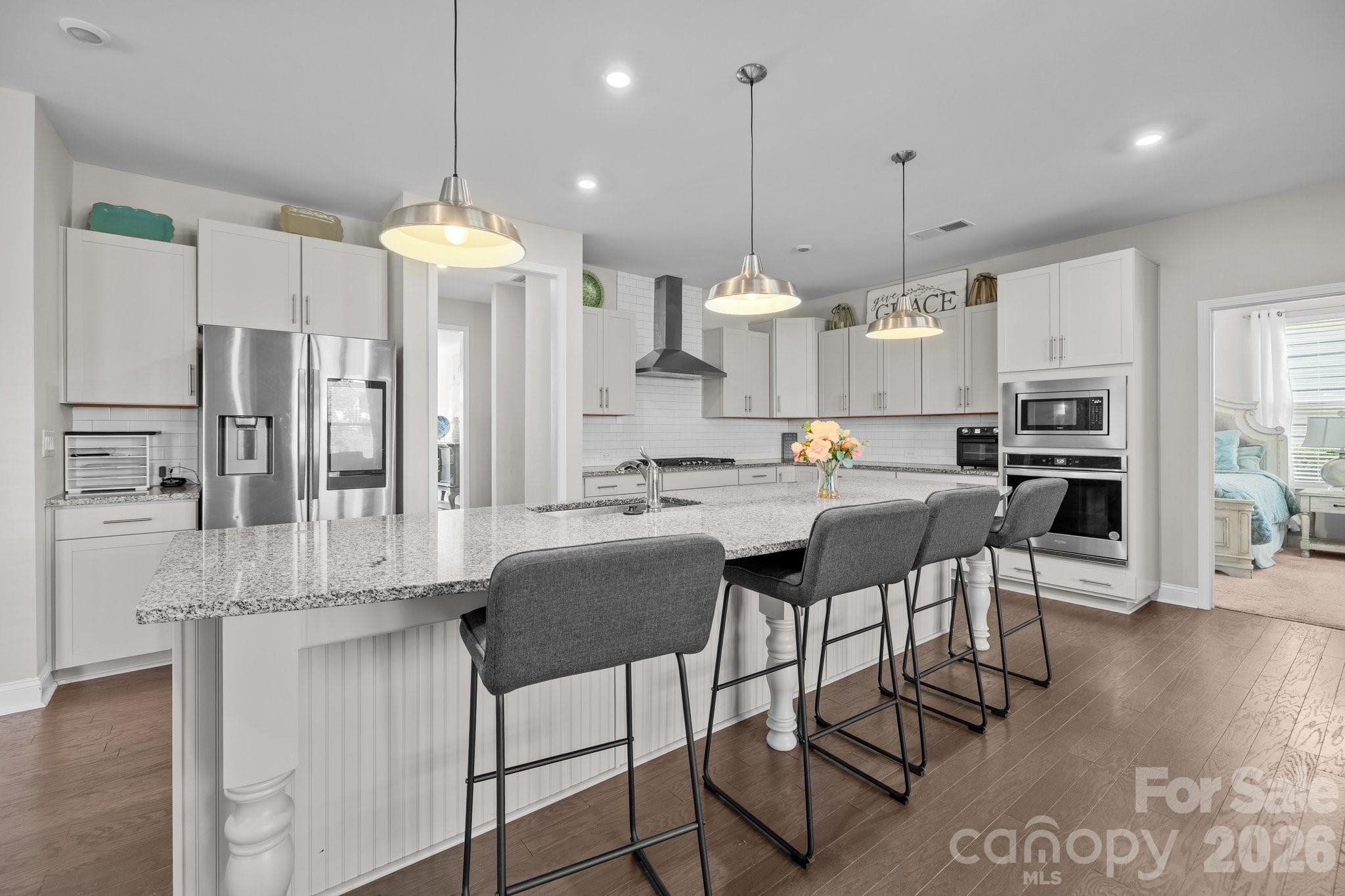241 Boxelder Road Clover, SC 29710 - Photo 13 of 35 a kitchen with stainless steel appliances kitchen island granite countertop a refrigerator a stove a kitchen island and chairs with wooden floor