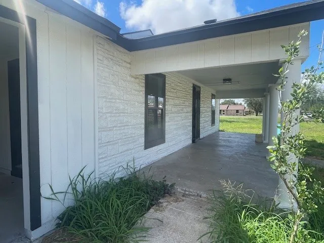a view of a yard in front of a house with a large tree