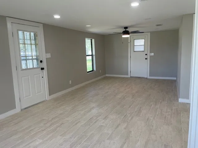 an empty room with windows and cabinet