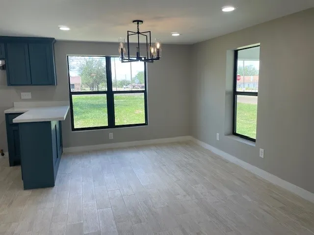 an empty room with windows and chandelier