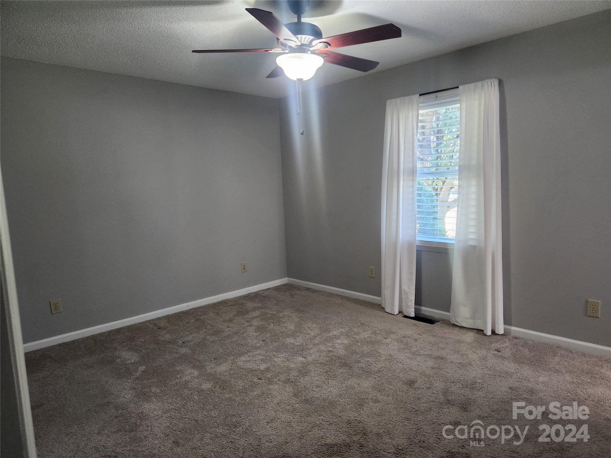 338 Helmstetler Road Lexington, NC 27295 - Photo 10 of 38 an empty room with windows and fan