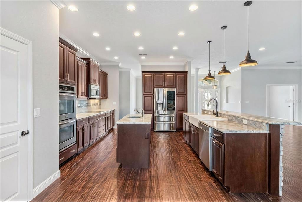 2350 Virgil Hall Road Lithia, FL 33547 - Photo 10 of 52 a kitchen with stainless steel appliances kitchen island granite countertop wooden floors and sink