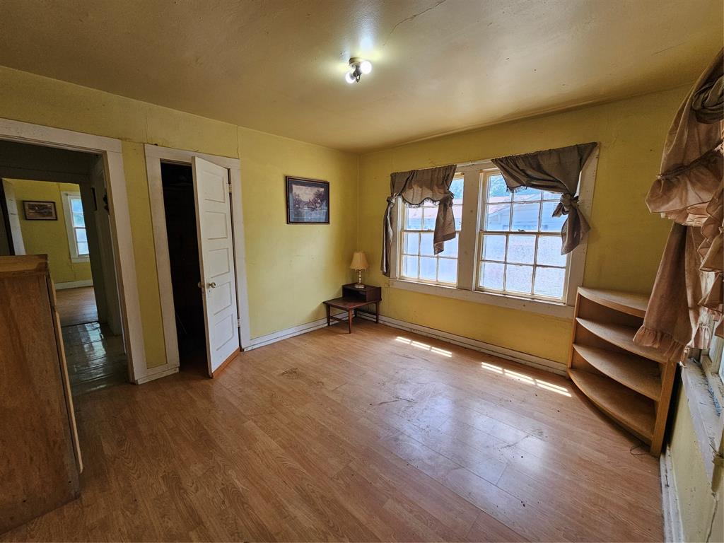 127 East Morgan Street Pilot Point, TX 76258 - Photo 13 of 25 Unfurnished bedroom with wood finished floors and baseboards