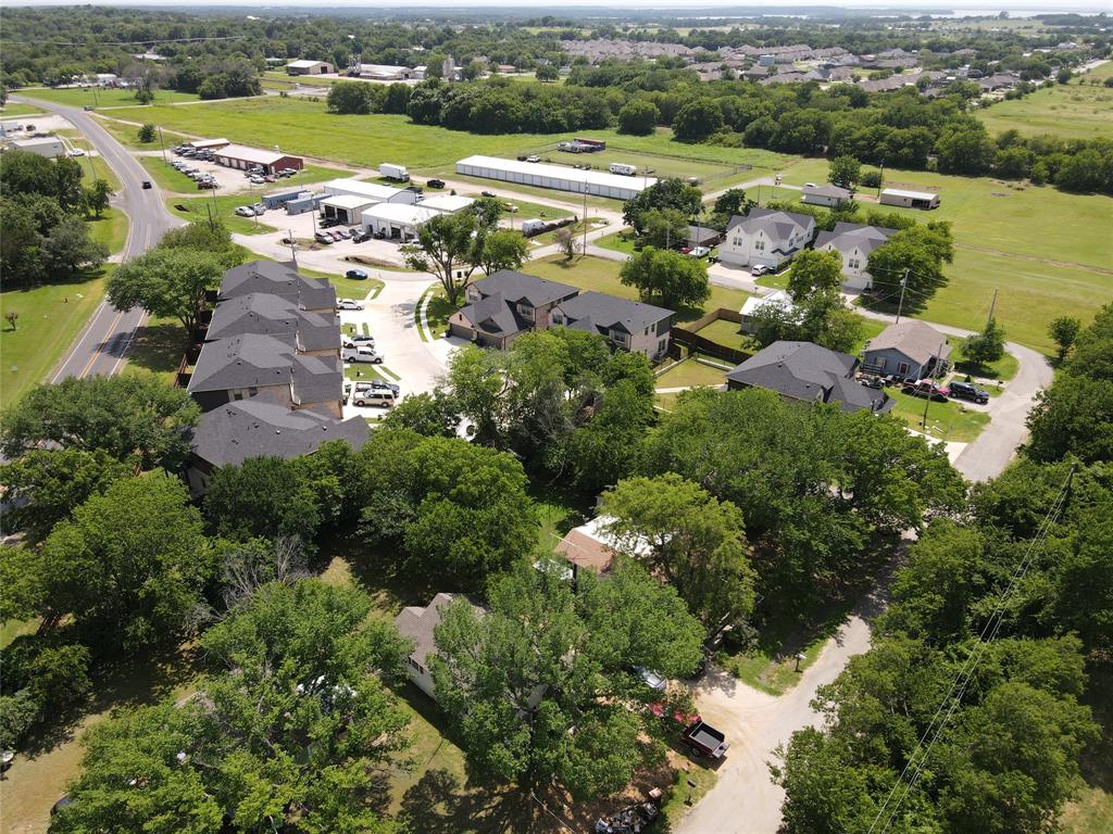 127 East Morgan Street Pilot Point, TX 76258 - Photo 24 of 25 Aerial view of residential area with a tree filled landscape