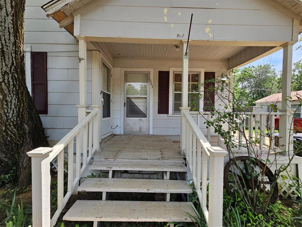 127 East Morgan Street Pilot Point, TX 76258 - Photo 9 of 25 View of exterior entry featuring covered porch