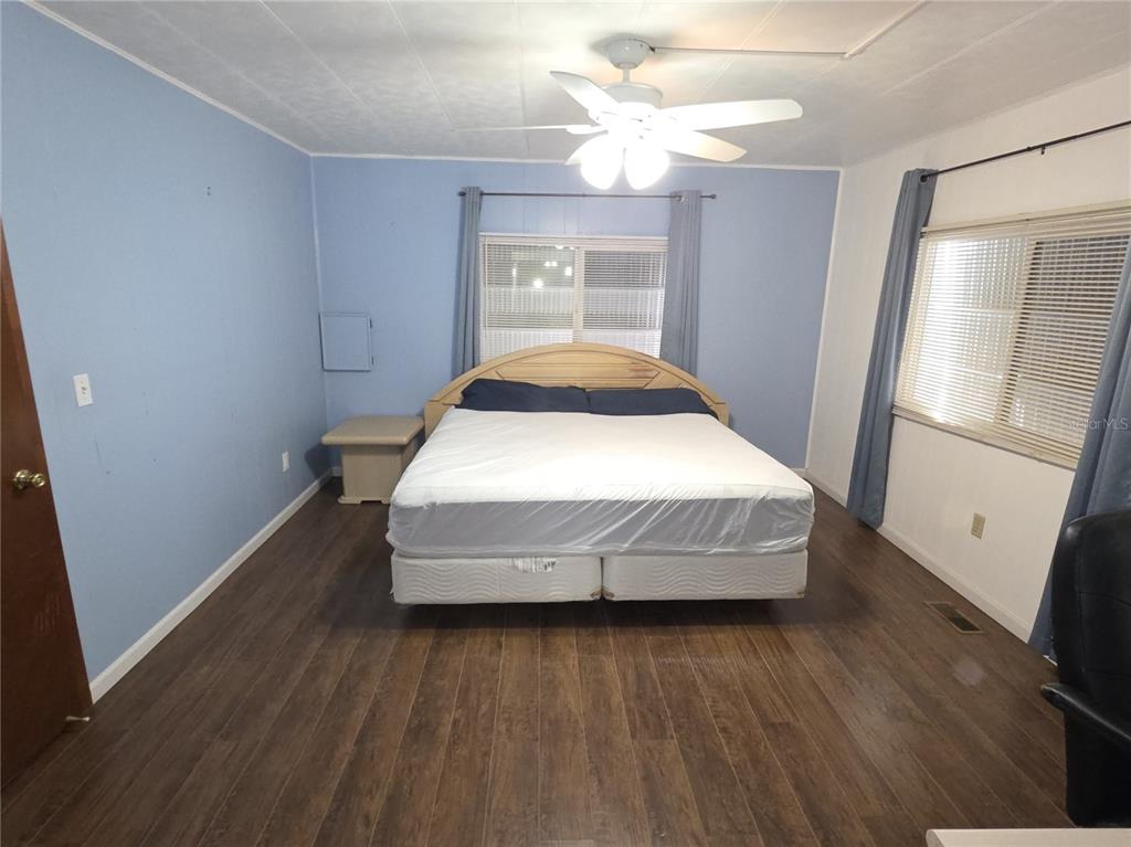 8071 Highpoint Boulevard Brooksville, FL 34613 - Photo 13 of 21 a spacious bedroom with a bed and wooden floor