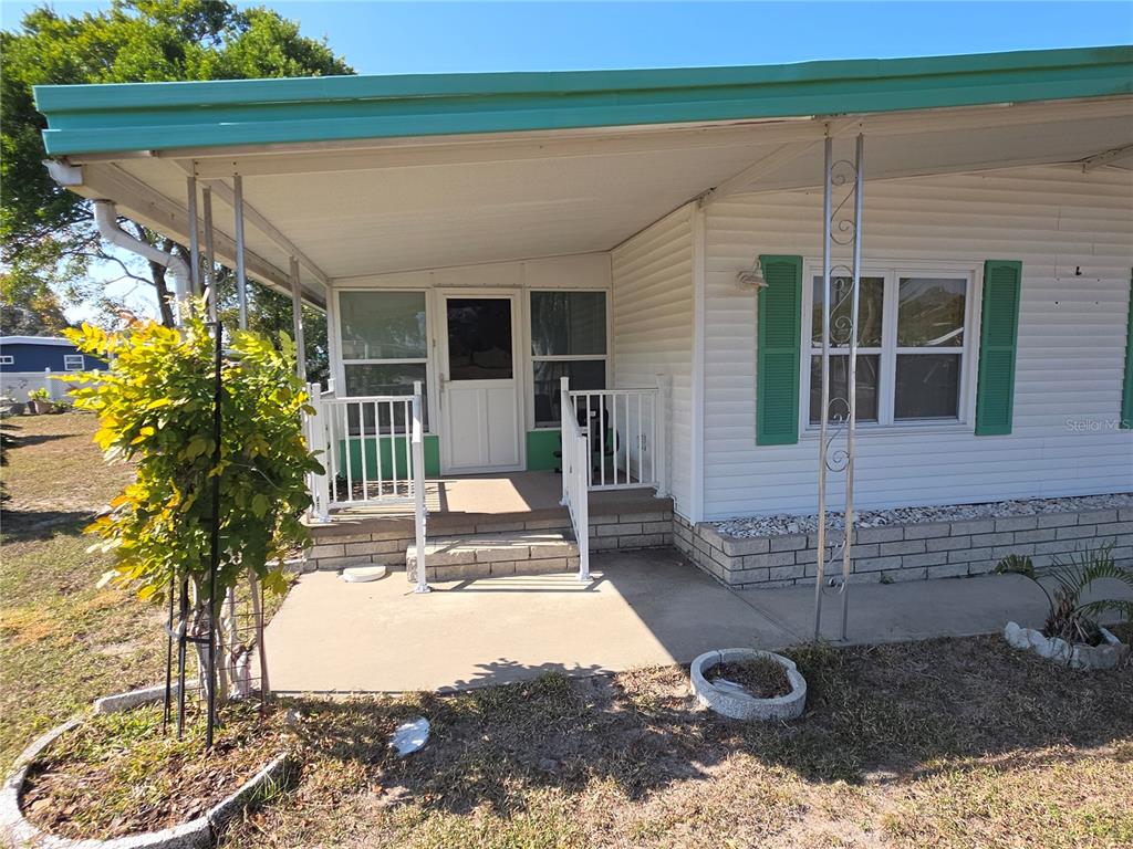 8071 Highpoint Boulevard Brooksville, FL 34613 - Photo 2 of 21 a view of a patio with table and chairs and potted plants