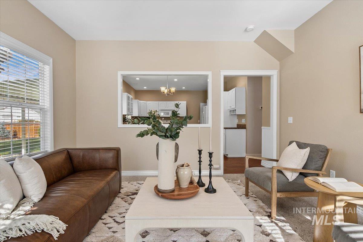 1075 North Purple Sage Way Eagle, ID 83616 - Photo 13 of 44 Living room featuring wood finished floors and a chandelier