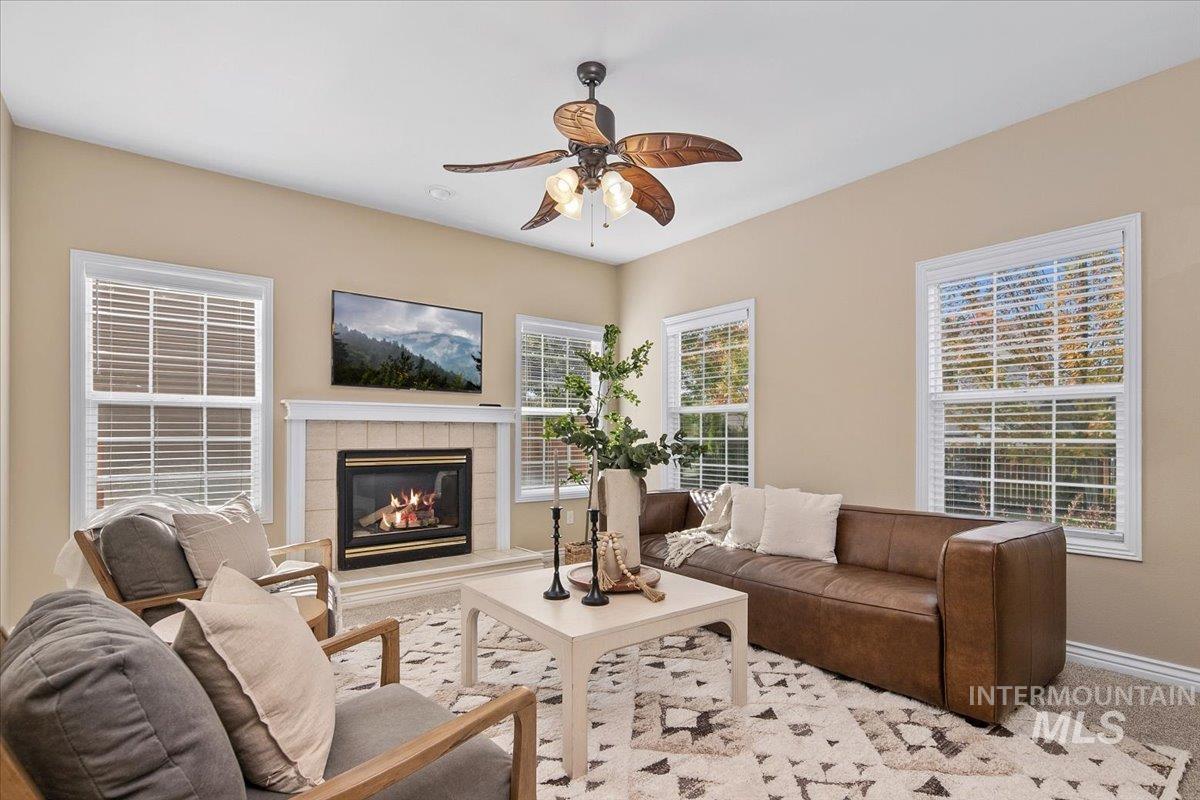 1075 North Purple Sage Way Eagle, ID 83616 - Photo 2 of 44 Carpeted living room with a tiled fireplace and ceiling fan