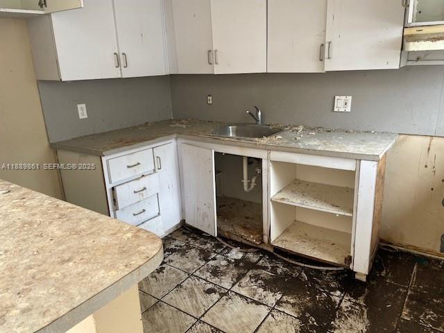 640 83rd Street Miami Beach, FL 33141 - Photo 6 of 13 a kitchen with granite countertop a sink and cabinets