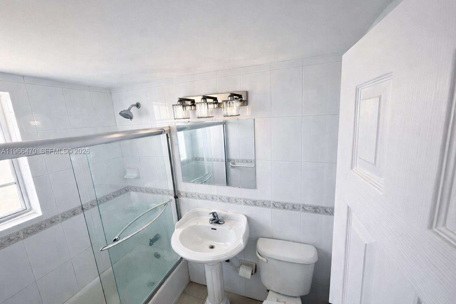 3450 Southwest 7th Street, Unit 3450 Miami, FL 33135 - Photo 2 of 7 a bathroom with a toilet sink and mirror