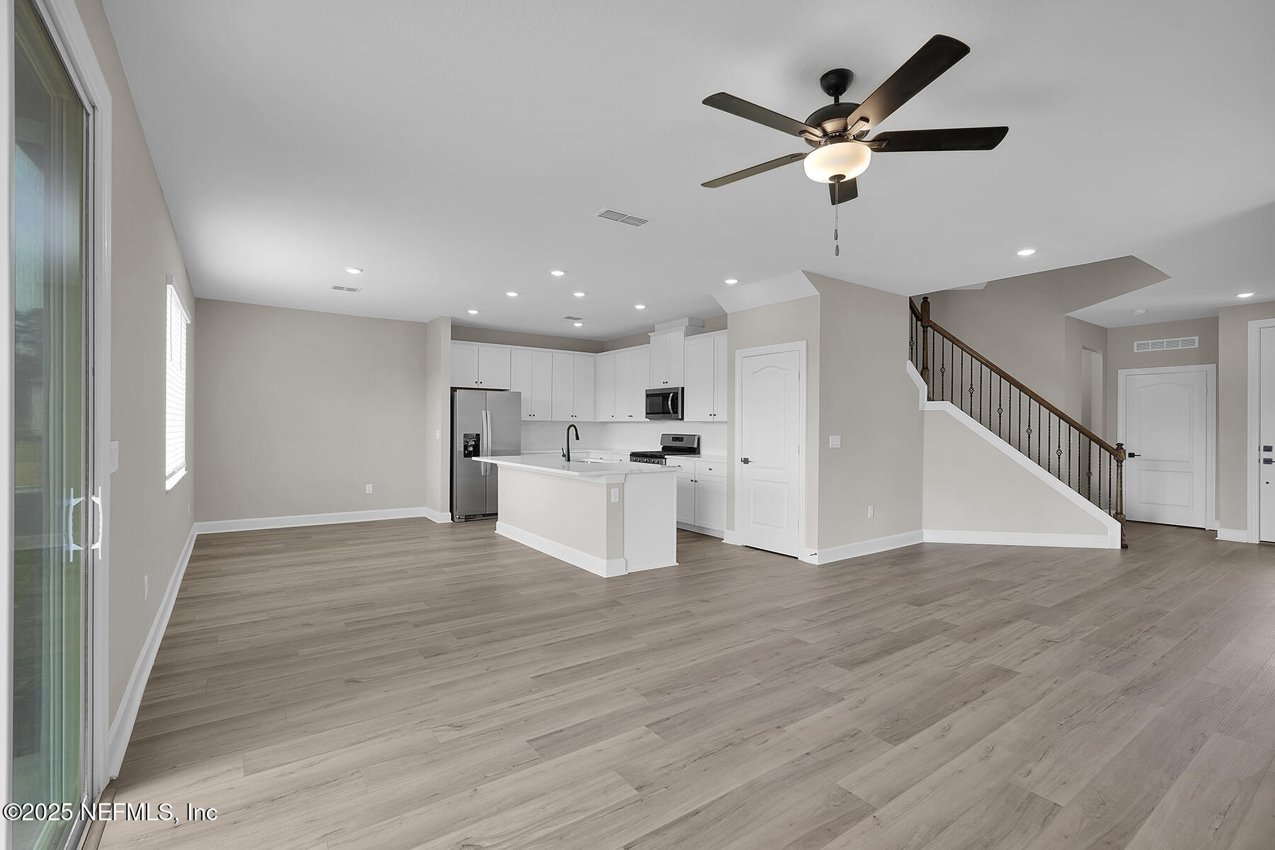 3987 Gareys Ferry Way Middleburg, FL 32068 - Photo 7 of 25 a view of an empty room with wooden floor and a ceiling fan