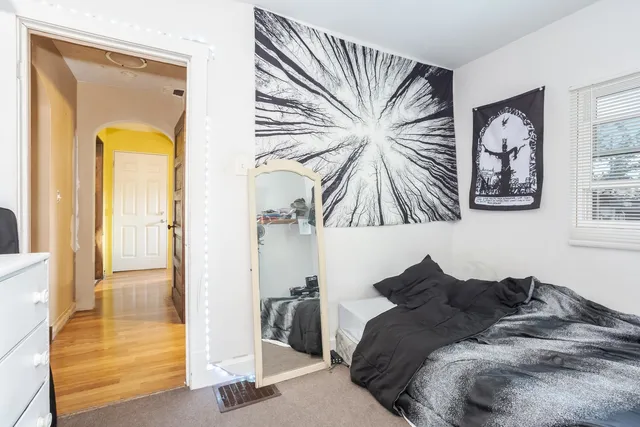 a bed room with a bed and a painting on the wall