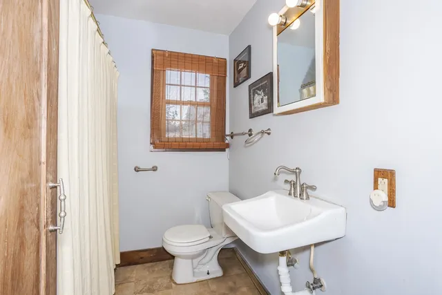 a bathroom with a toilet sink and mirror