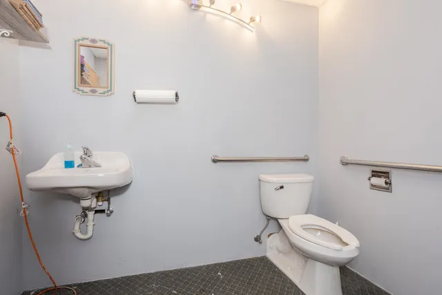 a bathroom with a sink a toilet and mirror