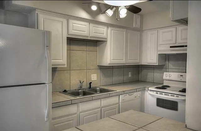a kitchen with stainless steel appliances granite countertop a sink and a refrigerator