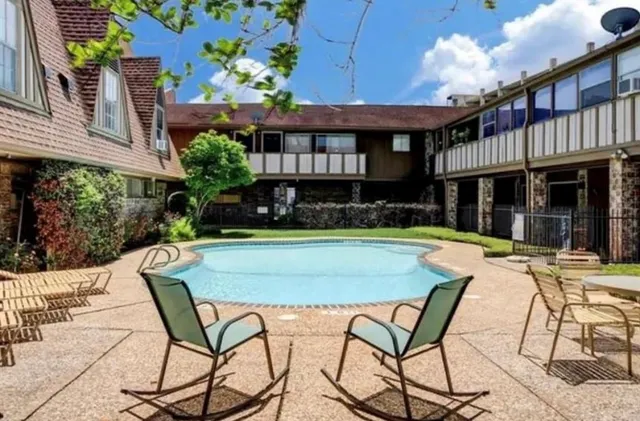 a view of a house with a swimming pool and sitting area