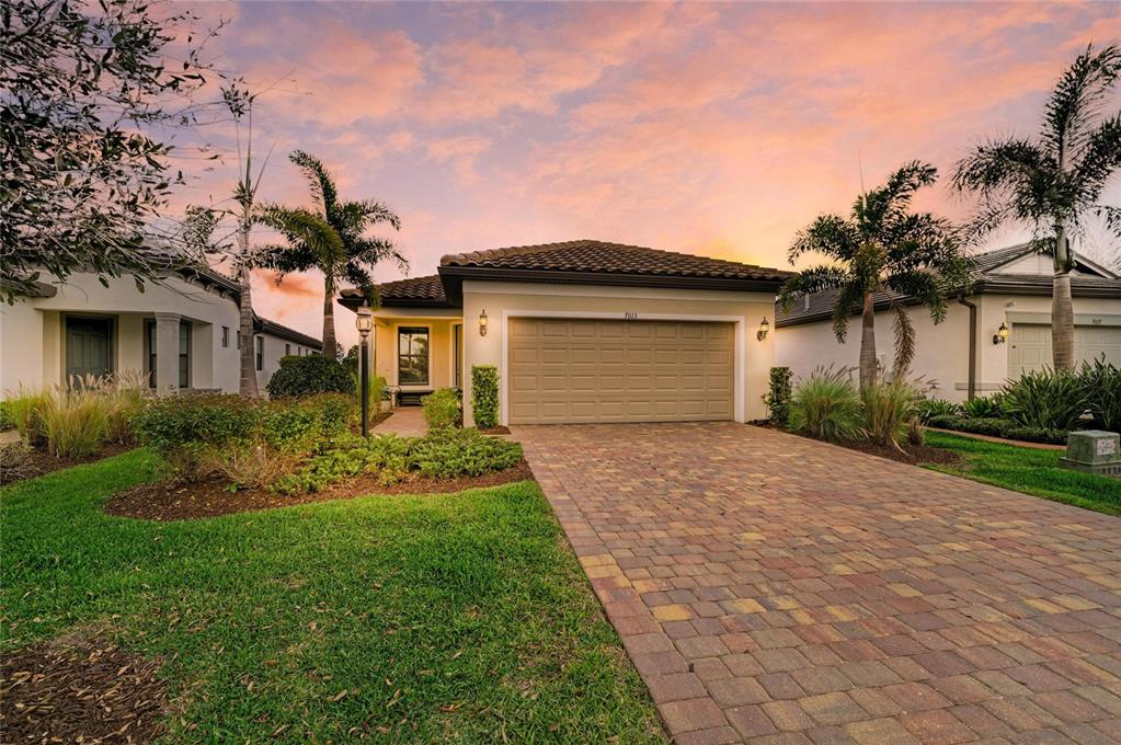 7013 Hanover Court Lakewood Ranch, FL 34202 - Photo 1 of 64 a front view of a house with a yard and garage