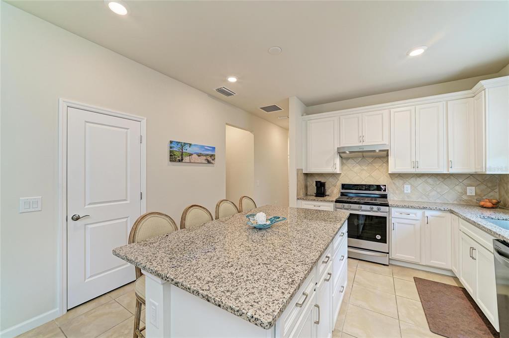 7013 Hanover Court Lakewood Ranch, FL 34202 - Photo 13 of 64 a kitchen with granite countertop white cabinets and stainless steel appliances