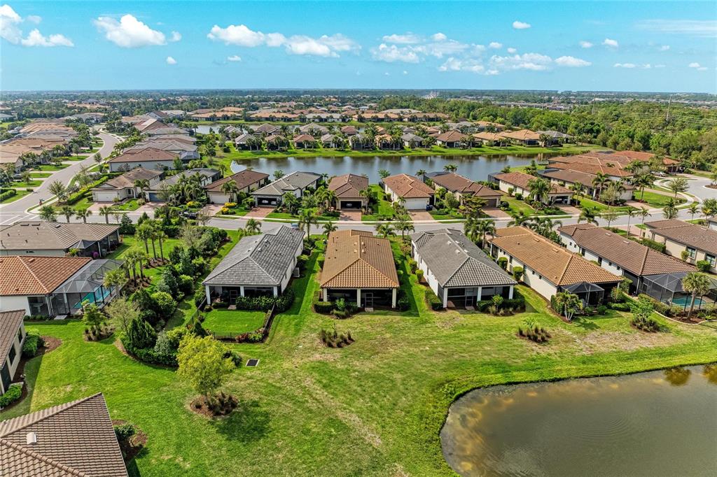 7013 Hanover Court Lakewood Ranch, FL 34202 - Photo 4 of 64 an aerial view of residential houses with outdoor space and lake view