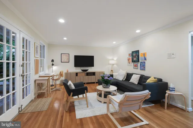 a living room with furniture a flat screen tv and a table