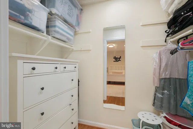 a view of walk in closet with clothes and shoes