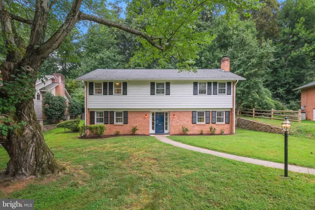 a view of a house with a big yard and large trees