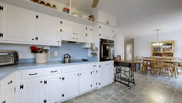 a kitchen with cabinets and chairs in it