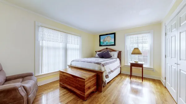 a bedroom with a bed and wooden floor