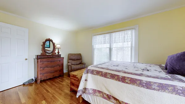 a bedroom with furniture and a wooden floor