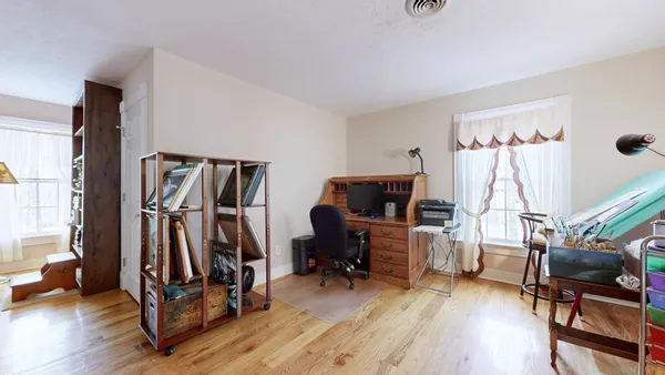 a view of a hallway with wooden floor and stairs