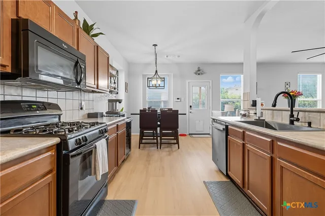 a kitchen with stainless steel appliances a stove sink and cabinets