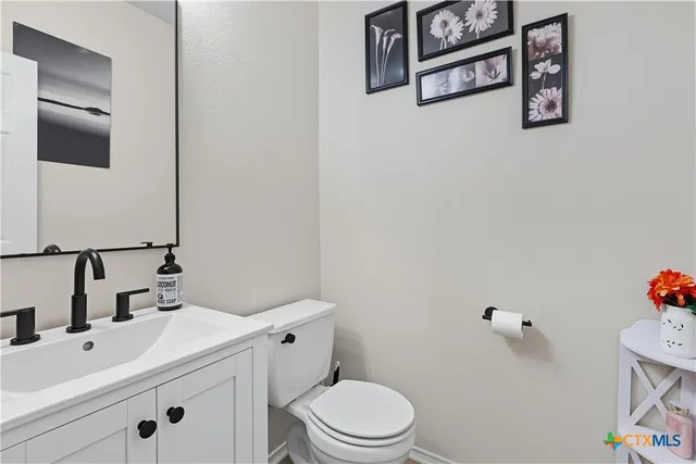 a bathroom with a sink mirror vanity and toilet