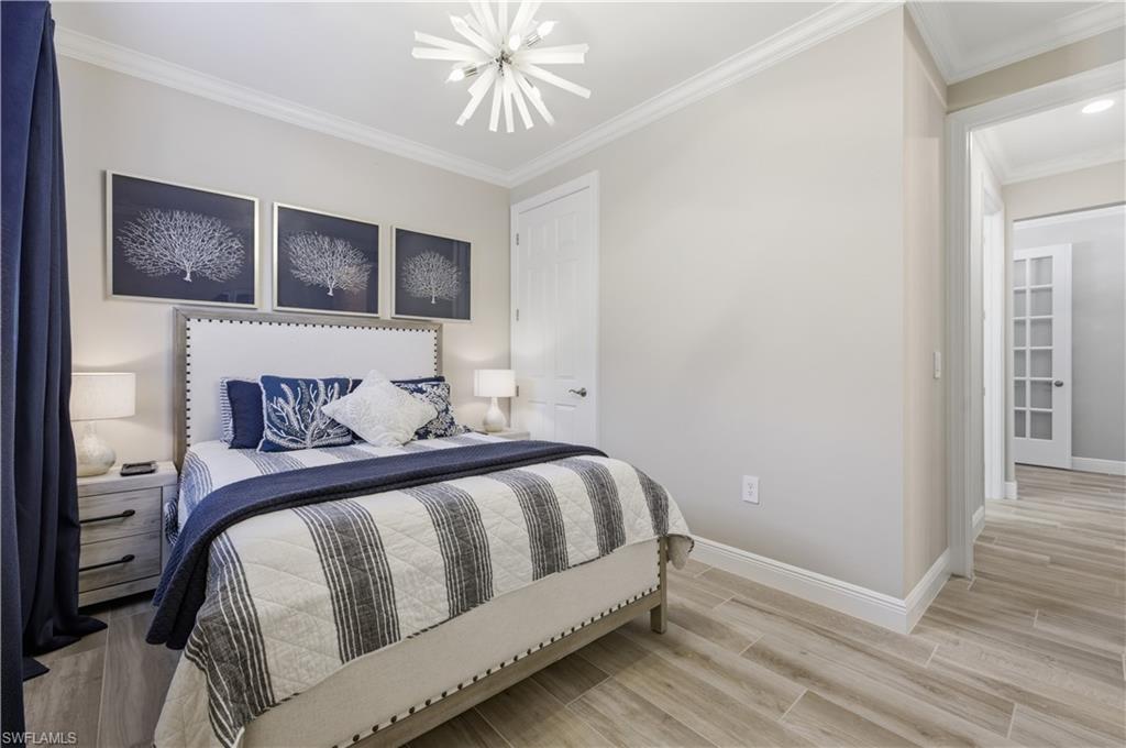 9761 Willet Court Naples, FL 34120 - Photo 11 of 44 a bedroom with a bed and wooden floor