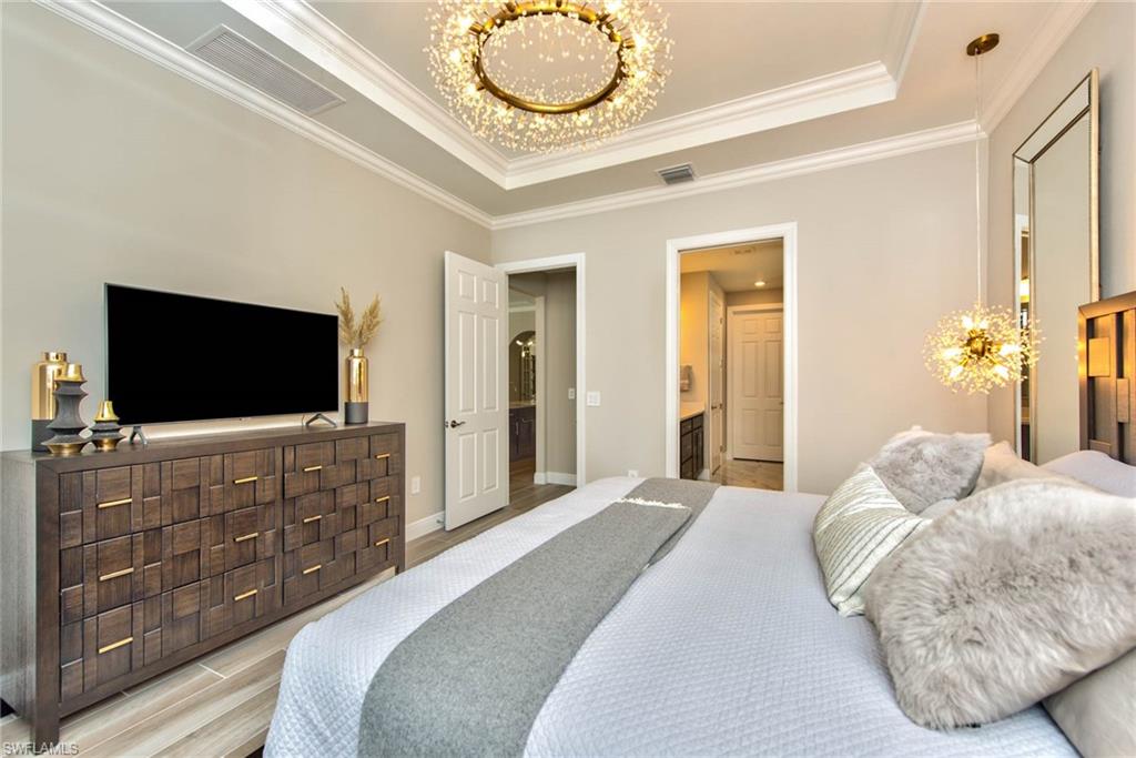 9761 Willet Court Naples, FL 34120 - Photo 13 of 34 a bedroom with a bed and a flat screen tv