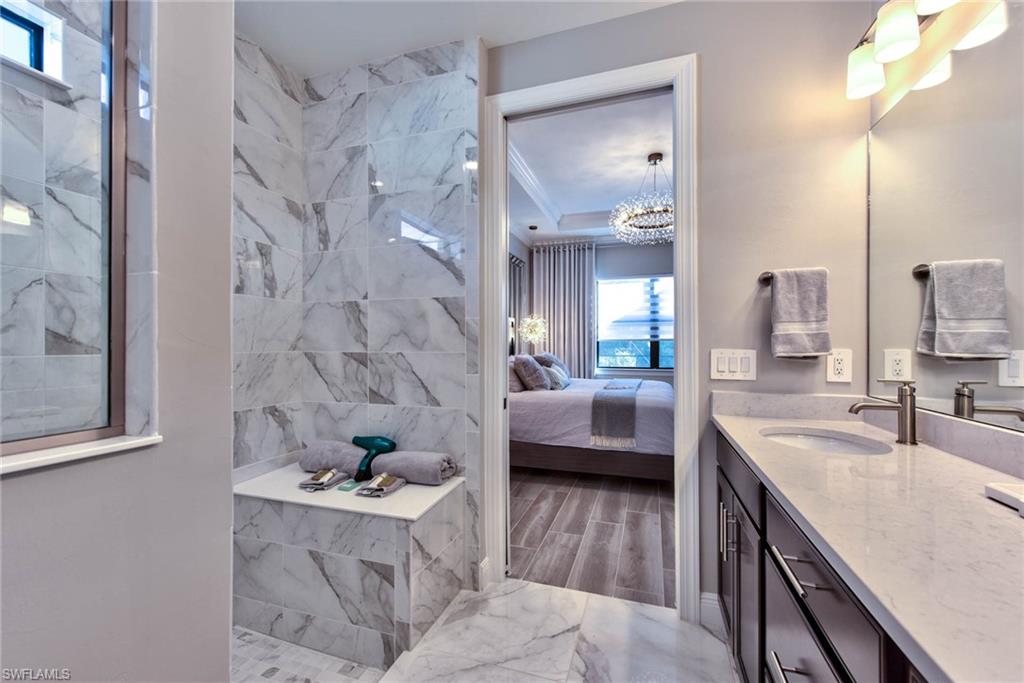 9761 Willet Court Naples, FL 34120 - Photo 14 of 34 a bathroom with a tub sink and mirror