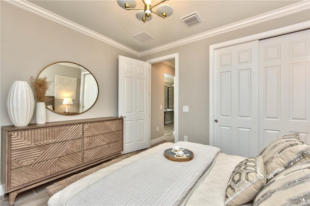 9761 Willet Court Naples, FL 34120 - Photo 15 of 34 a bedroom with a bed a mirror and dresser