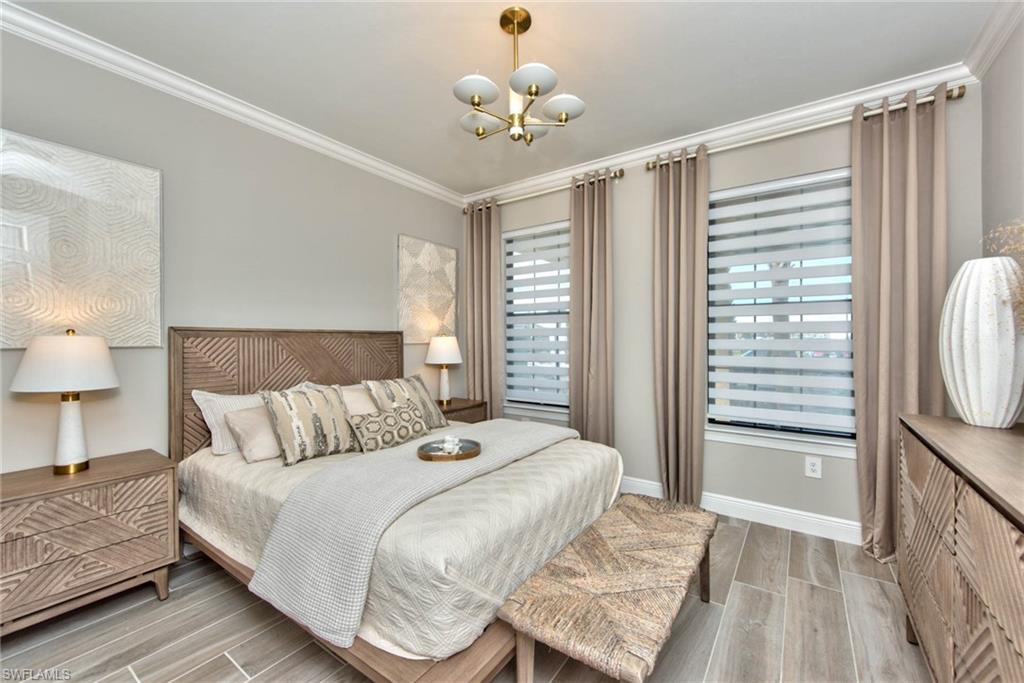 9761 Willet Court Naples, FL 34120 - Photo 16 of 34 a bedroom with a bed and a chandelier