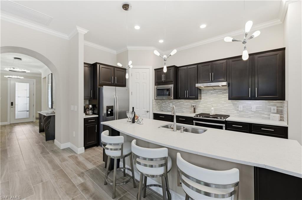 9761 Willet Court Naples, FL 34120 - Photo 17 of 44 a large kitchen with a table and chairs