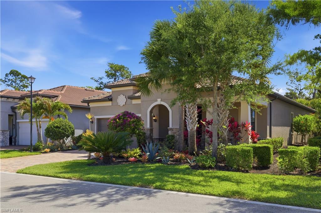 9761 Willet Court Naples, FL 34120 - Photo 2 of 44 a front view of a house with a yard and potted plants