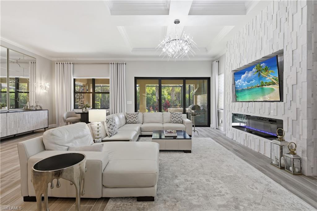 9761 Willet Court Naples, FL 34120 - Photo 21 of 44 a living room with furniture a fireplace and a flat screen tv