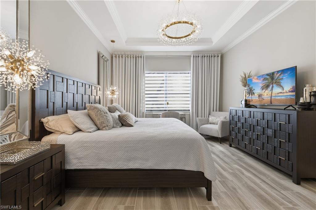 9761 Willet Court Naples, FL 34120 - Photo 26 of 44 a bedroom with a bed wooden floor and window