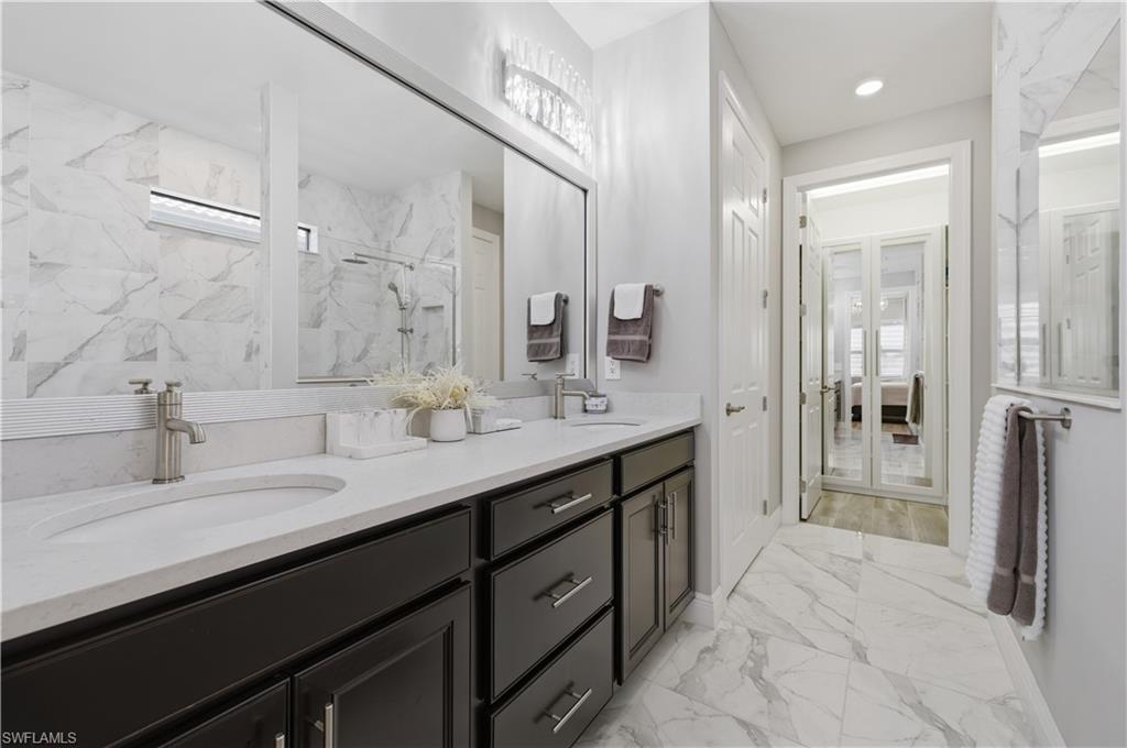9761 Willet Court Naples, FL 34120 - Photo 28 of 44 a spacious bathroom with double sink and a mirror