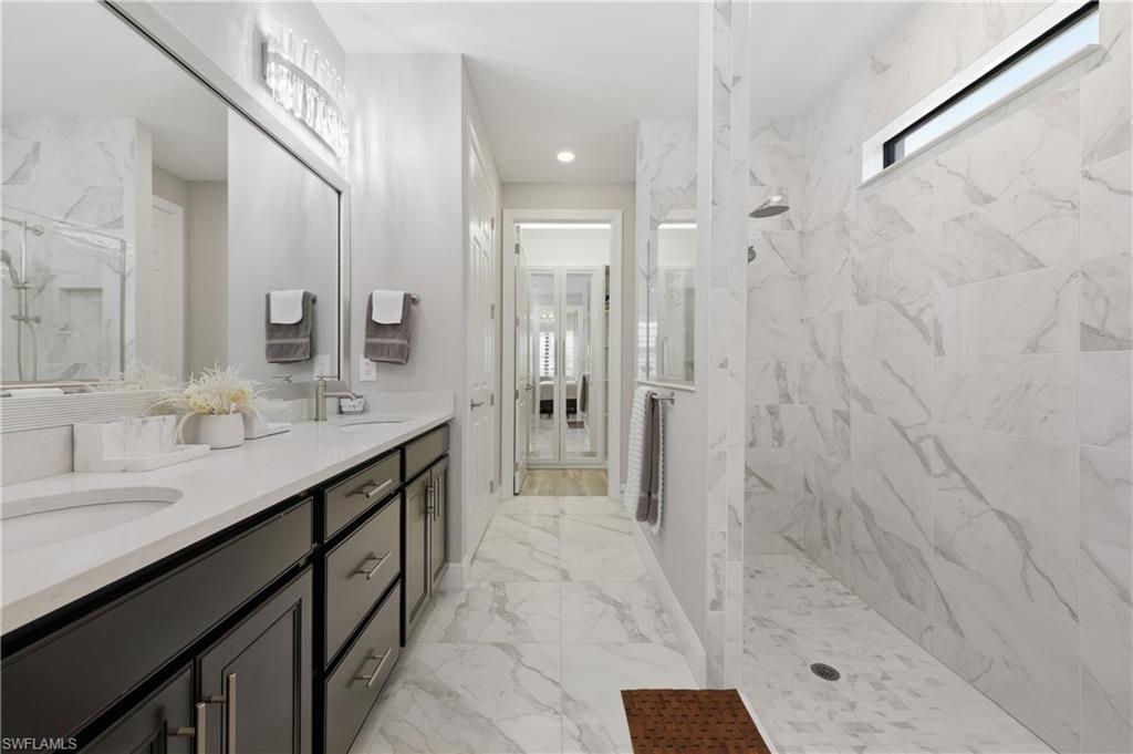 9761 Willet Court Naples, FL 34120 - Photo 29 of 44 a spacious bathroom with a shower sink and mirror