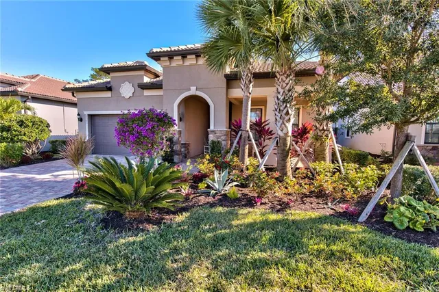 a front view of a house with a yard and potted plants