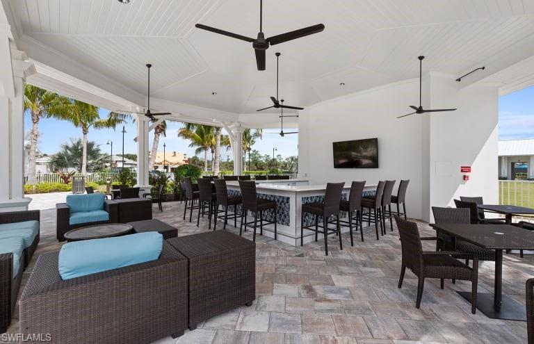 9761 Willet Court Naples, FL 34120 - Photo 32 of 34 a living room with lots of furniture and a chandelier