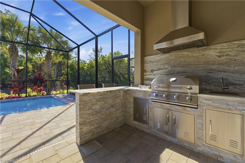 9761 Willet Court Naples, FL 34120 - Photo 35 of 44 a kitchen with stainless steel appliances kitchen island granite countertop a refrigerator and a stove