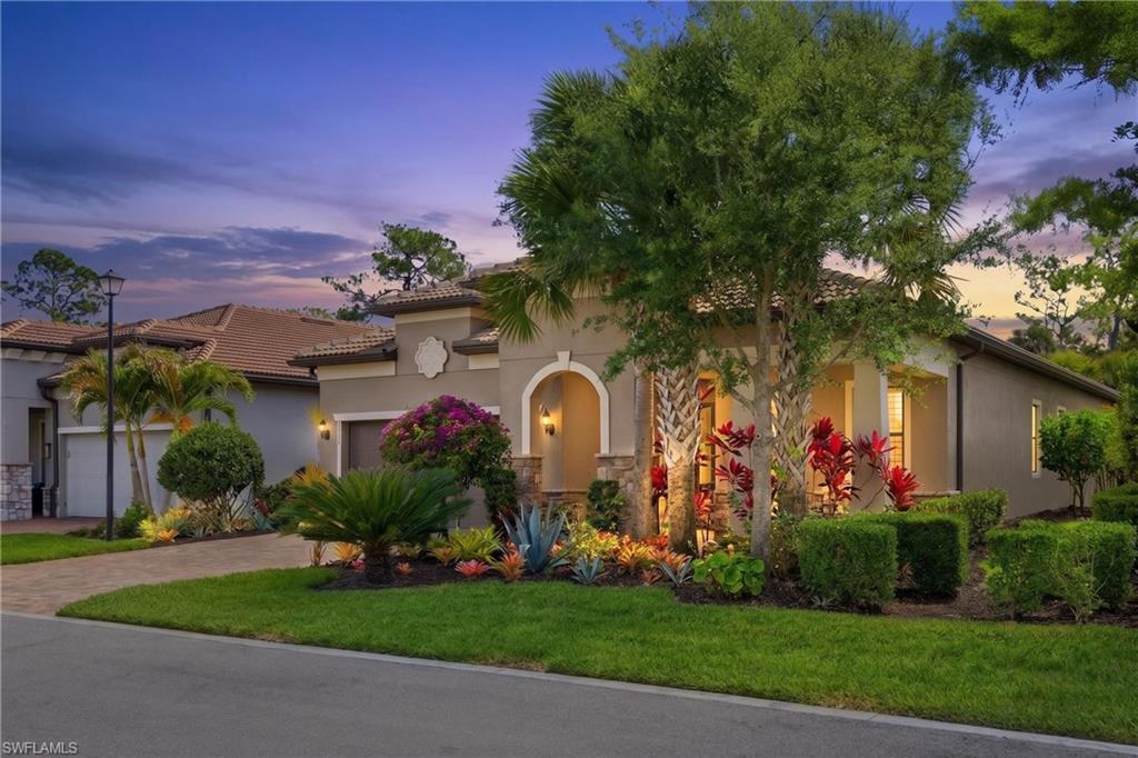 9761 Willet Court Naples, FL 34120 - Photo 38 of 44 a front view of a house with a yard and potted plants