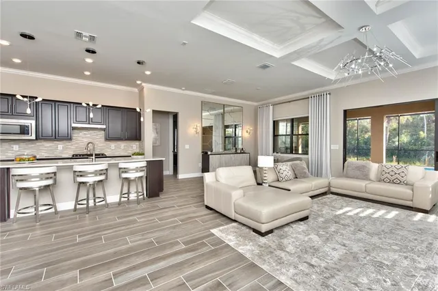 a living room with furniture and a dining table with kitchen view