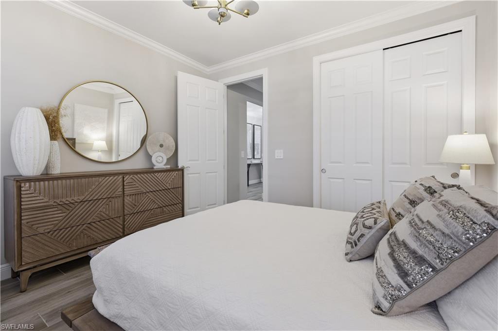 9761 Willet Court Naples, FL 34120 - Photo 7 of 44 a bedroom with a bed a mirror and lamp on dresser